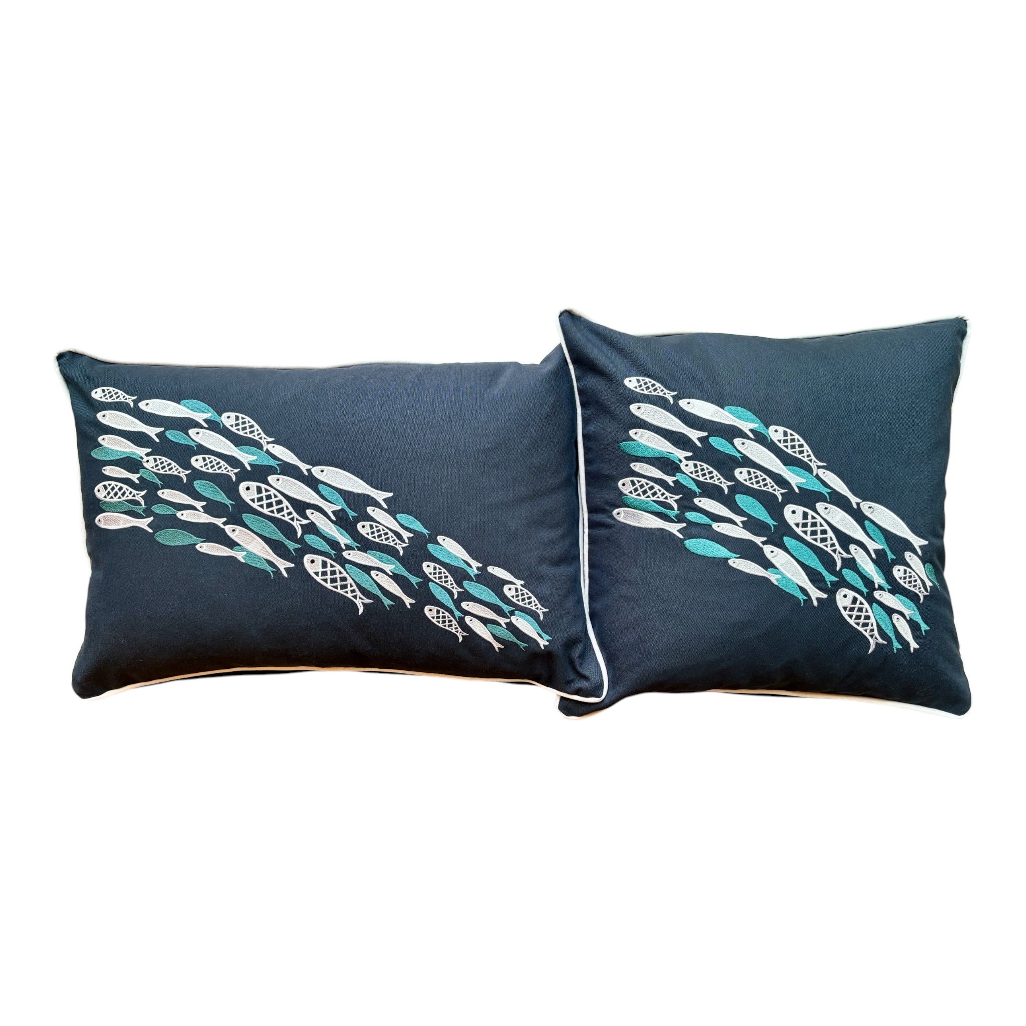 Aqua Dance decorative pillow in azure color, measuring 18 x 18 inches , featuring three overlapping teal fish-shaped embroidery designs on a rectangular blue fabric. Designed for life at sea, it combines durability, elegance, and a tranquil marine-inspired aesthetic.