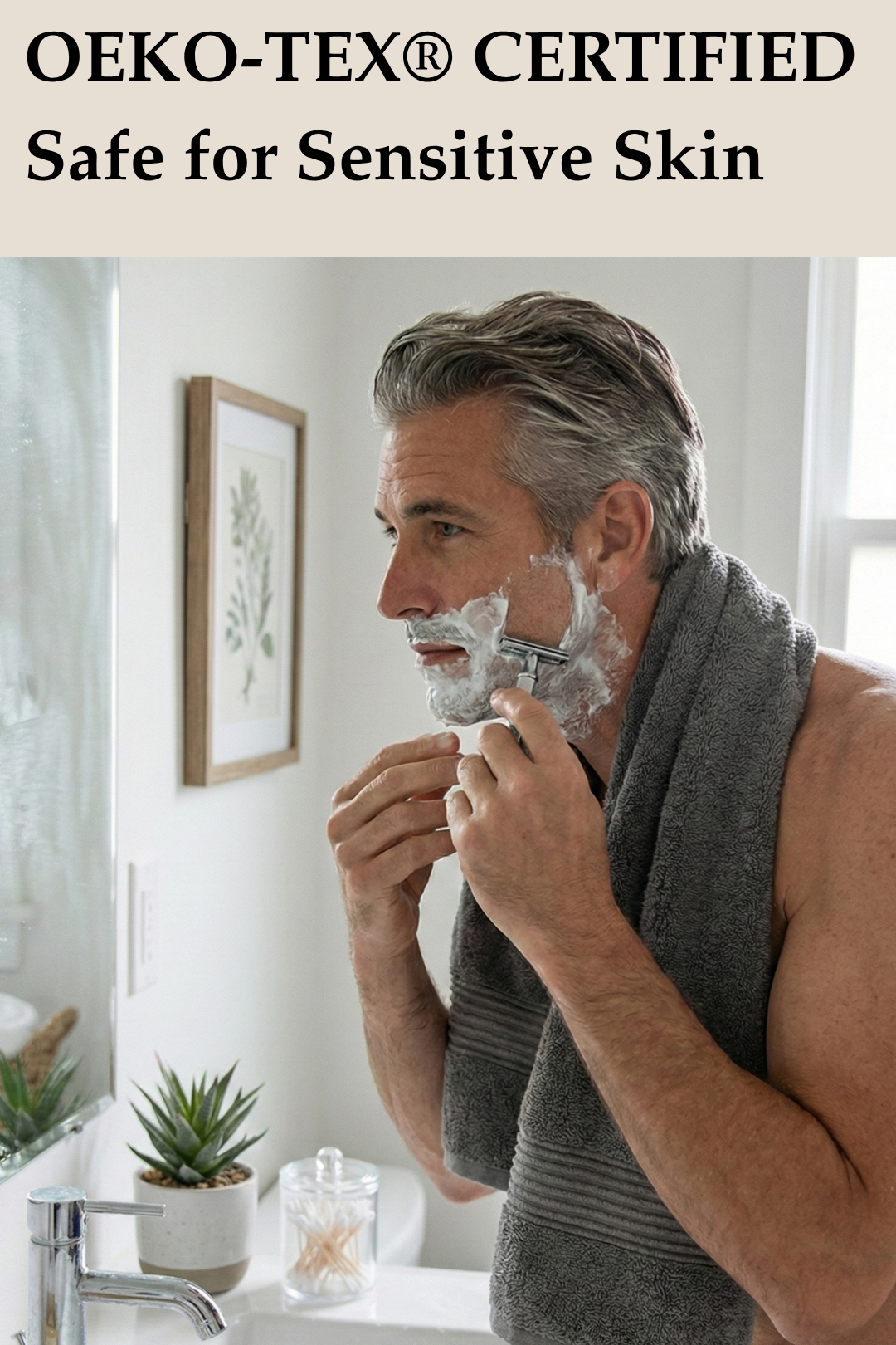 Man using a charcoal grey OEKO-TEX certified face towel around his neck while shaving to protect sensitive skin.