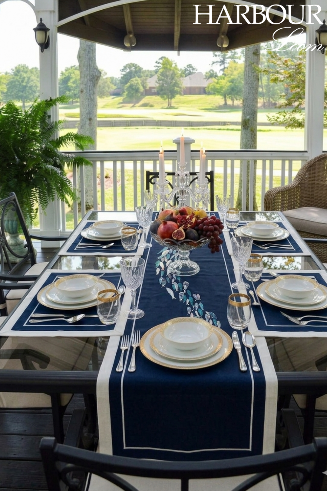 Dining table set for a meal with a scenic view outside, featuring a navy blue runner and white plates.