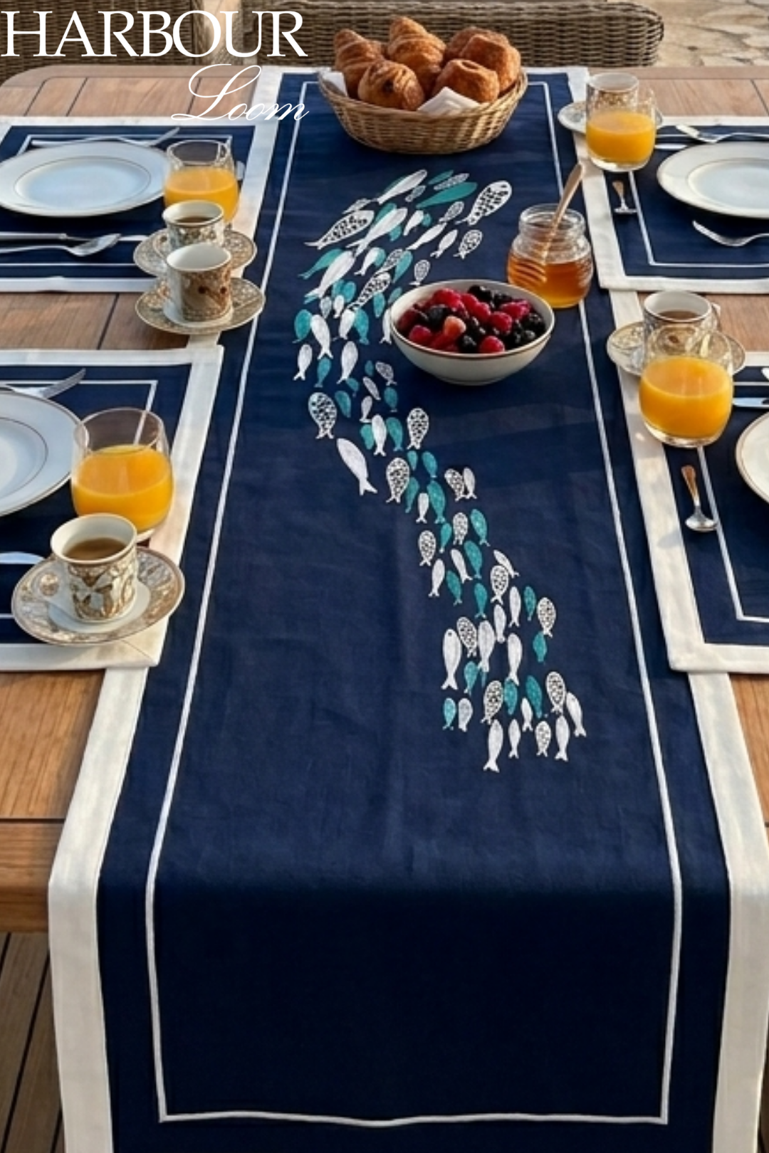 Nautical-themed table runner with embroidered fish design on a dining table setting.