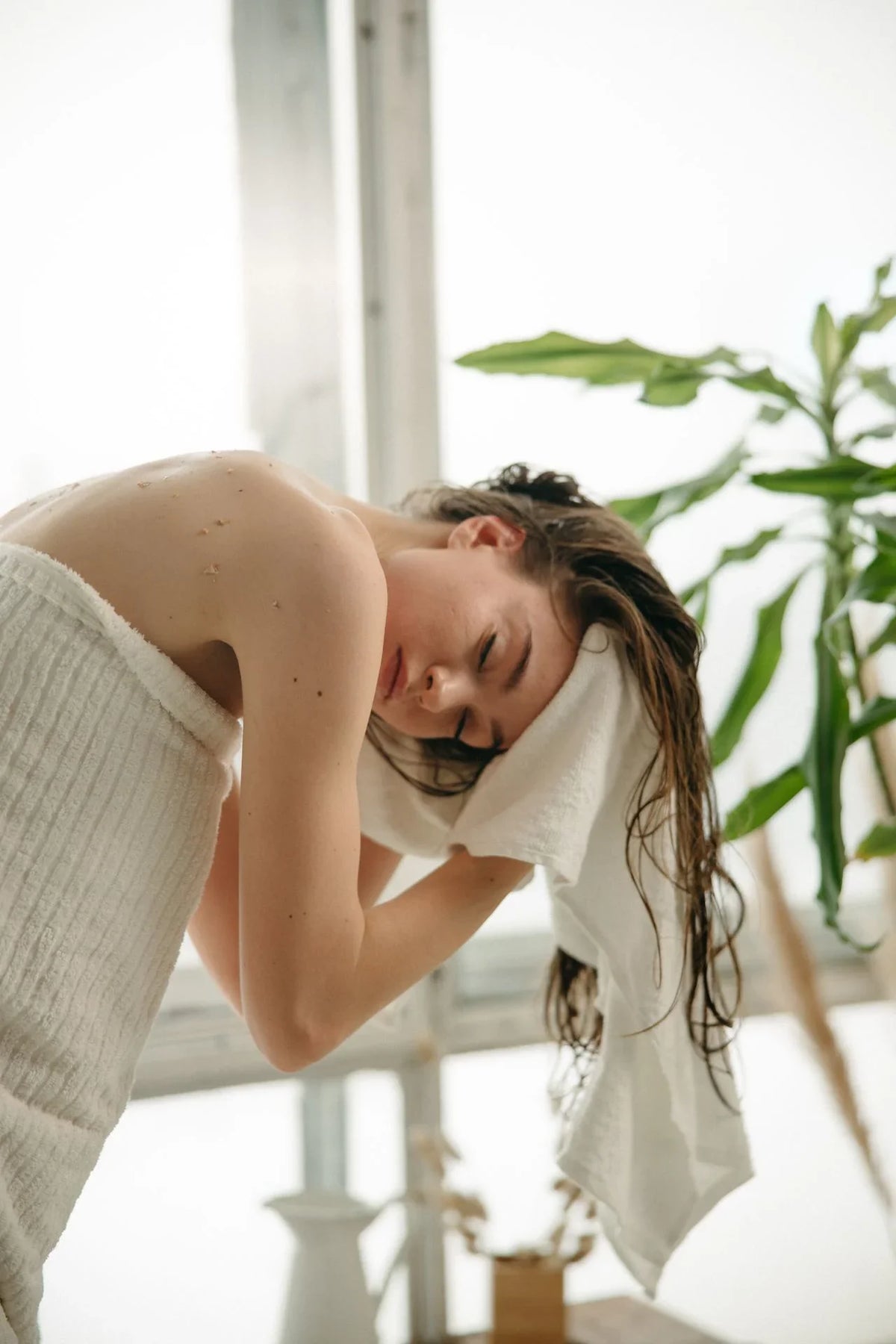 a girl drying her hair using towel
