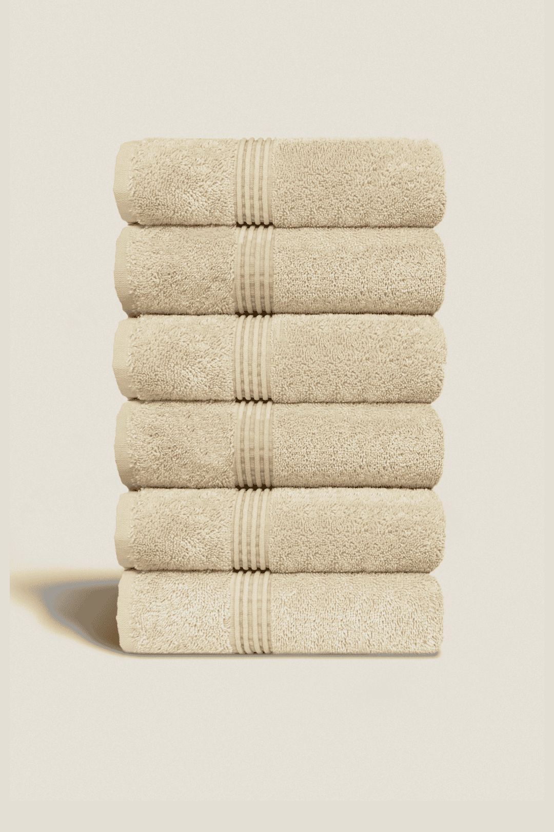 Set of 6 ivory face towels made from ultra-soft Aegean cotton, neatly stacked to highlight their texture and elegant finish.