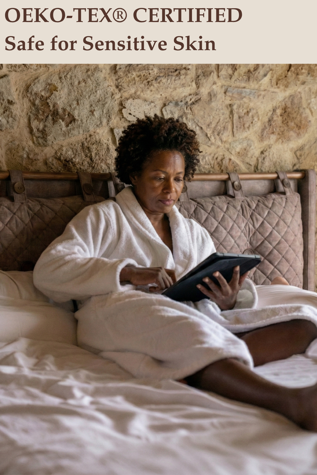 Woman in a white robe using a tablet on a bed with 'OEKO-TEX® CERTIFIED Safe for Sensitive Skin' text above.