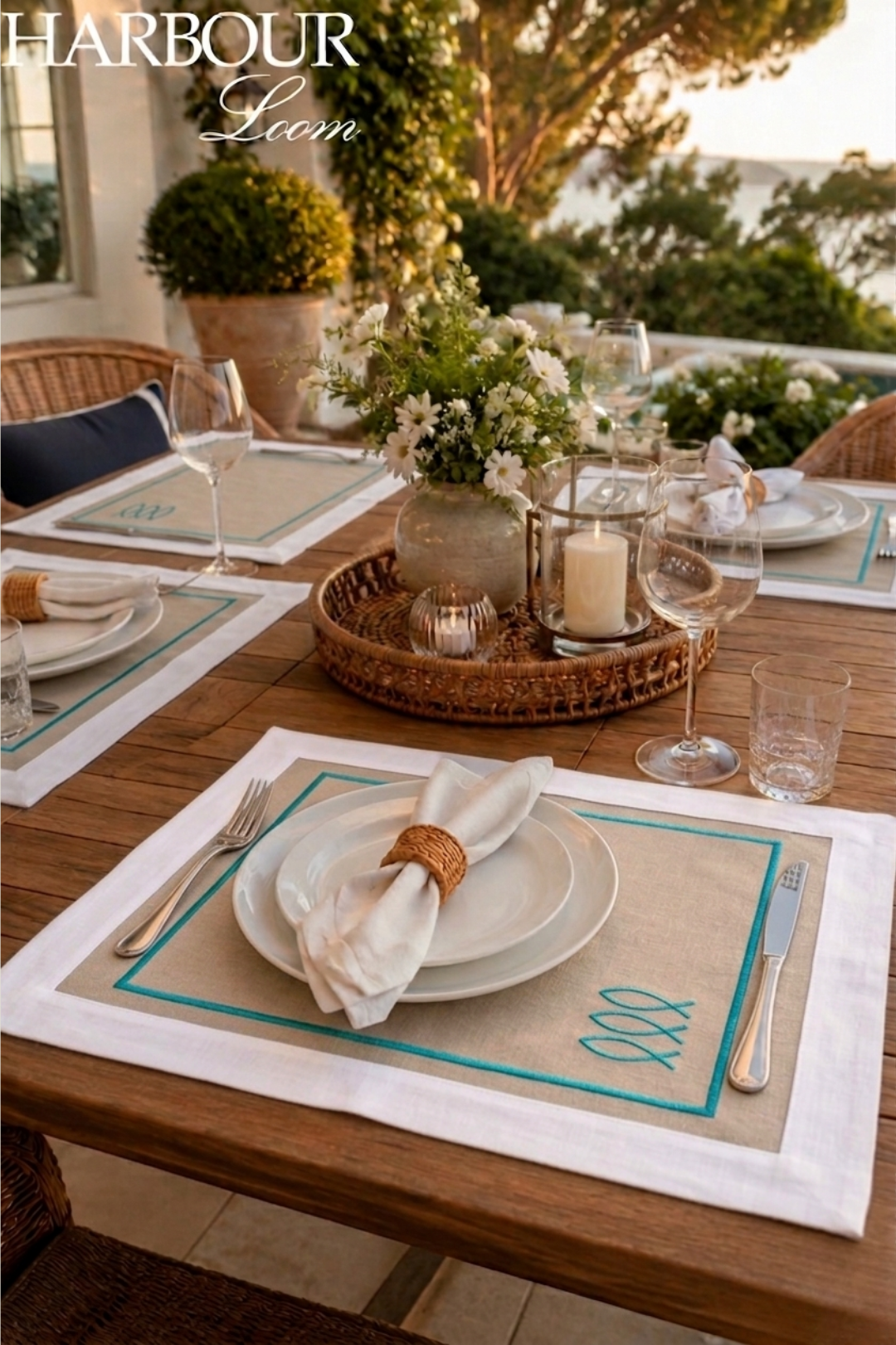 Elegant outdoor dining setup with place settings and decor on a wooden table.